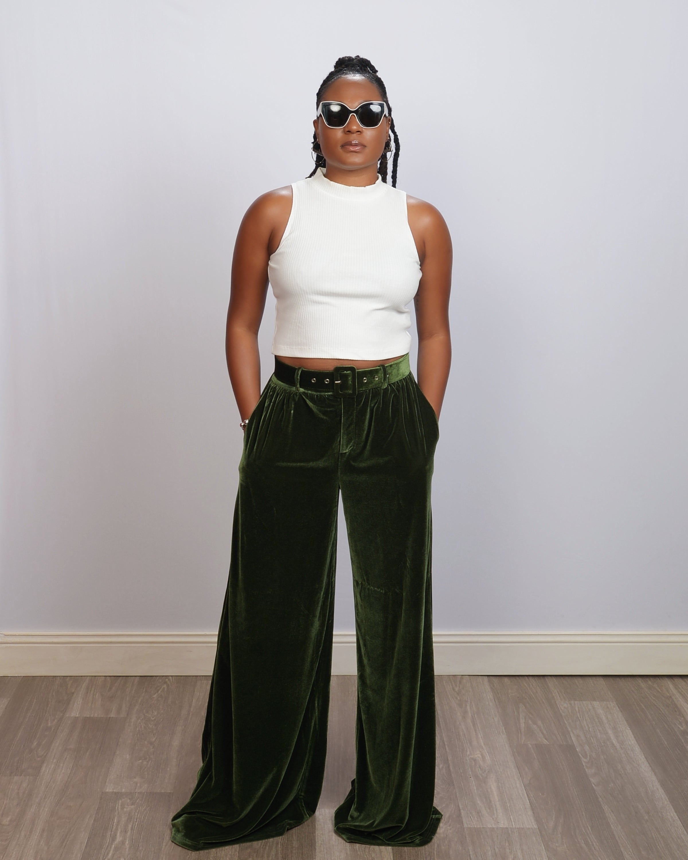 Tall woman wearing green, velvet wide-leg pants, showing the dramatic length and high waist fit.